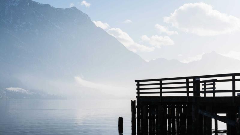 A sleek, modern laptop sitting on a stylish home office desk with a warm cup of coffee next to it, showcasing a vibrant OLED screen.