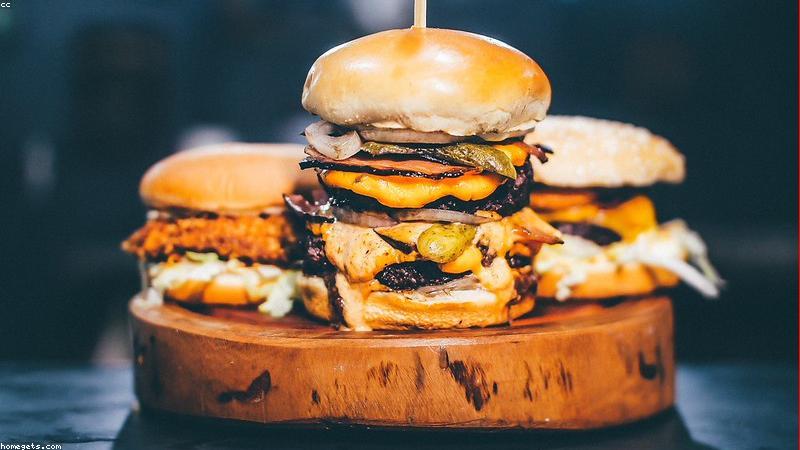 Close up of the Anker Prime portable charger showing its bright OLED screen displaying charging wattage, resting next to a modern laptop.