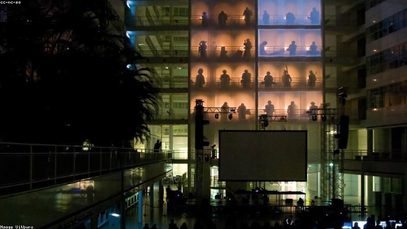 A modern vertical farming setup inside a refurbished shipping container, utilizing purple LED grow lights and hydroponic systems.