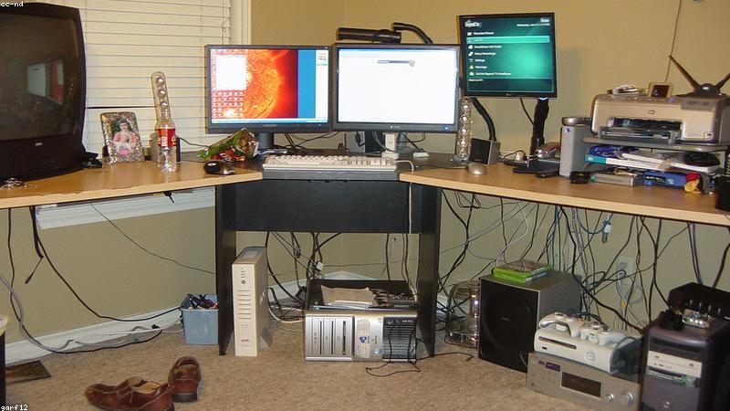 dual monitor setup on motorized standing desk with ergonomic mesh chair in home office