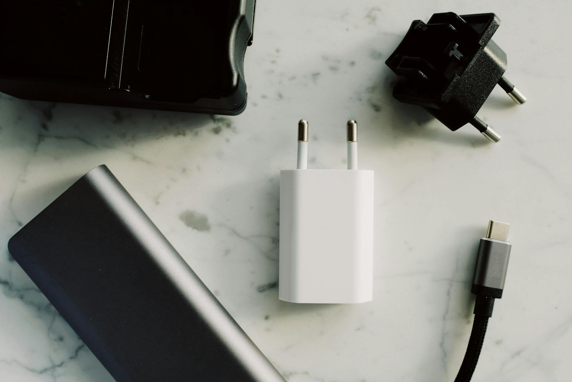 A collection of electronic adapters and chargers featuring USB-C and other connectors on a marble surface.
