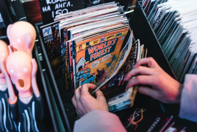 Hands sorting through vintage comic books in a store, focusing on 'World's Finest.'