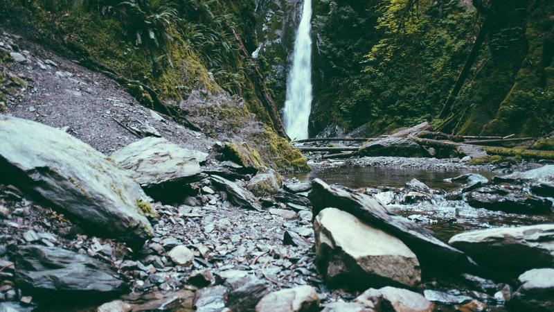 The Zendure SuperTank Pro charging a modern MacBook Air, showcasing its bright OLED display with real-time wattage numbers.