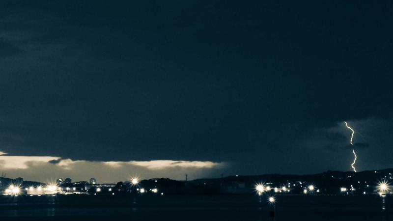 A minimalist bedroom with subtle, warm circadian lighting and a discrete smart sleep tracking sensor on the nightstand