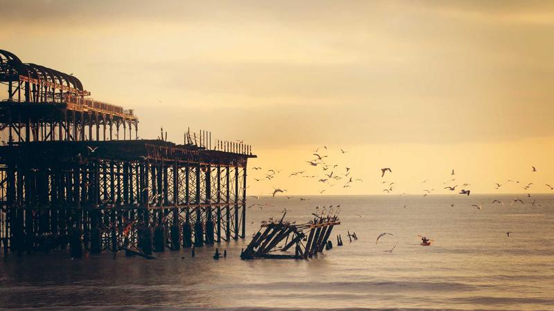 A close-up graphic showing the user interfaces of Apple's watchOS with its honeycomb app grid, Google's Wear OS with its tile interface, and a lightweight RTOS interface side-by-side.