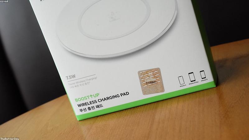 wireless charging pad with modern smartphone resting on it in a bright minimalist office setup