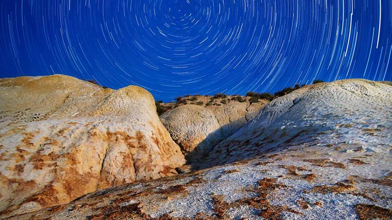 A modern home office setup with a laptop, notebook, and a cup of coffee on a wooden desk, symbolizing a startup founder working on a side hustle.