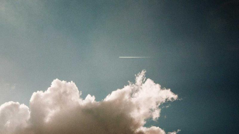 A wire-free robotic lawnmower maintaining a pristine yard while connected to a smart irrigation system on a sunny day.